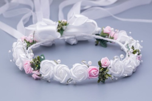 Pełne białe i różowe różyczki tworzą klasyczną komunijną kompozycję.