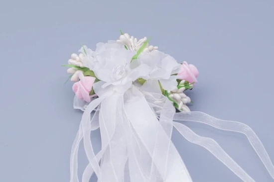 Zwiewne białe kwiaty tworzą lekką i elegancką dekorację świecy.