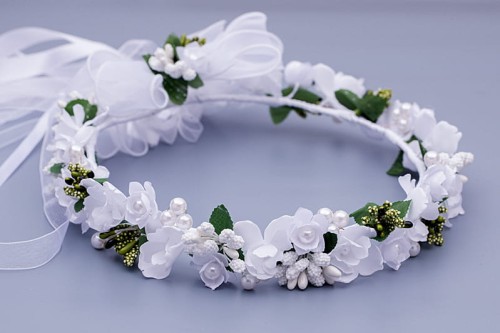 Drobne białe kwiaty i perełki tworzą elegancką, komunijną kompozycję.