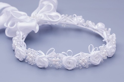 Satynowe różyczki tworzą klasyczną, elegancką kompozycję komunijną.