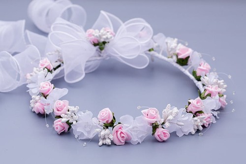 Pudrowo-różowe różyczki delikatnie przełamują klasyczną biel wianka.