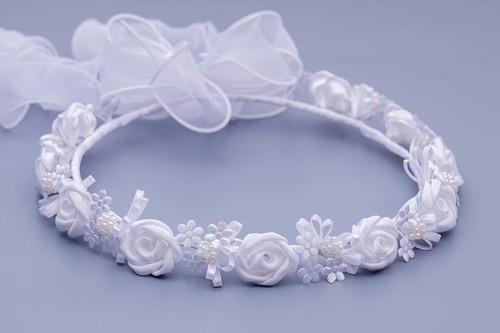 Białe różyczki i drobne kwiaty tworzą klasyczną, komunijną kompozycję.