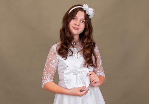 Delikatna koronka podkreśla uroczysty charakter torebki.