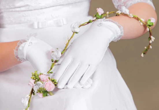 Klasyczne białe rękawiczki komunijne o eleganckim, ponadczasowym kroju.