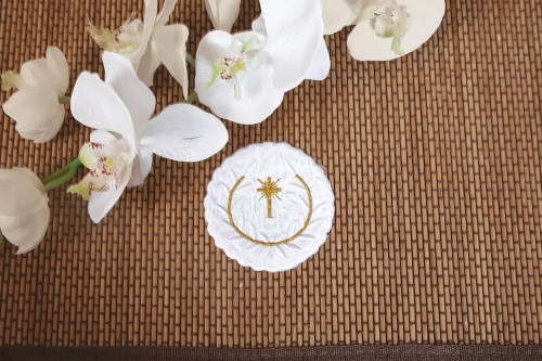 Haftowany emblemat z symbolem IHS i motywem hostii.