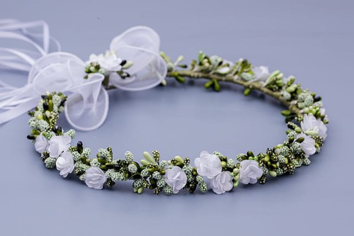 Drobne białe kwiaty i zielone pączki tworzą świeżą, naturalną kompozycję.