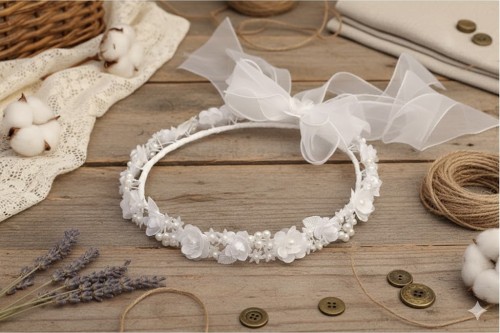 Delikatna kokarda z organzy podkreśla uroczysty wygląd ozdoby.