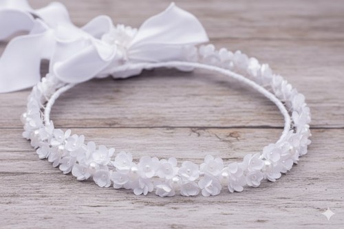 Elegancka kokarda z wstążkami delikatnie dopełnia całą formę.