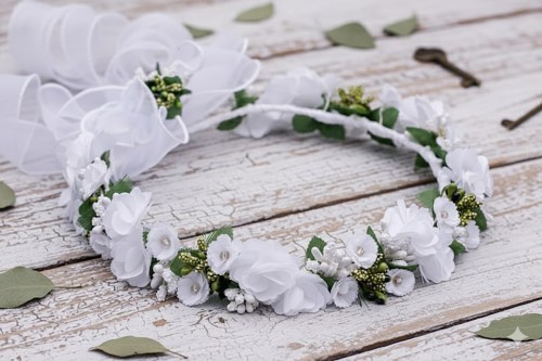 Subtelna kokarda z organzy podkreśla uroczysty charakter ozdoby.