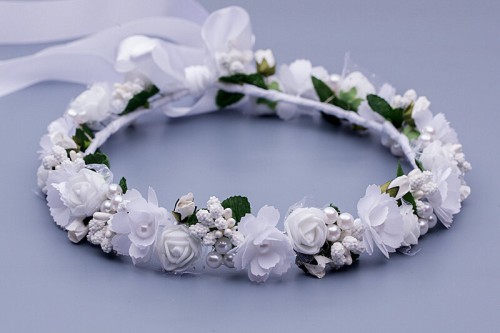 Białe różyczki i drobne kwiaty tworzą klasyczną, komunijną kompozycję.