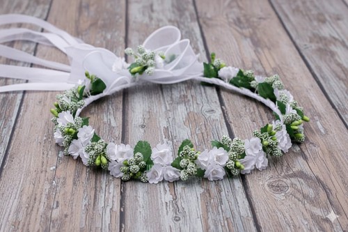 Zwiewna kokarda z organzy subtelnie dopełnia całość.