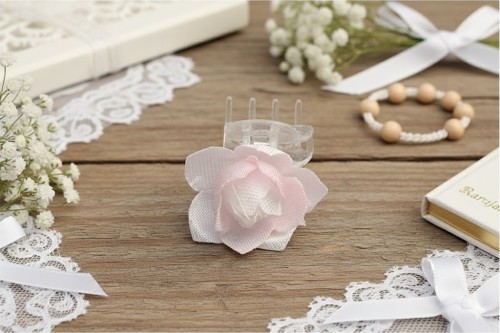 Delikatny kwiat w jasnej bieli i pudrowym różu tworzy subtelną ozdobę komunijną.