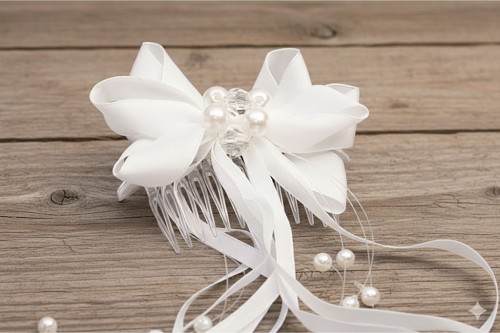 Satynowa kokarda z perłowo-kryształowym środkiem.