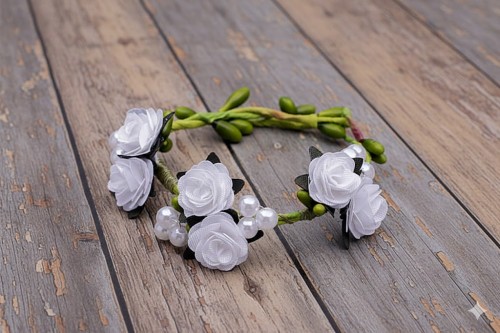 Białe kwiaty tworzą jasną i klasyczną kompozycję komunijną.