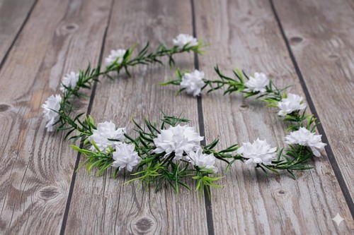 Delikatne białe kwiaty i zielone listki tworzą naturalną kompozycję.