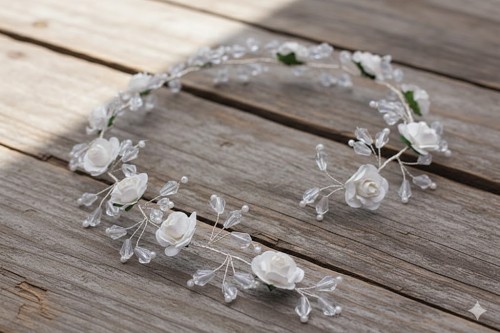 Białe różyczki i kryształki tworzą lekką, biżuteryjną kompozycję.