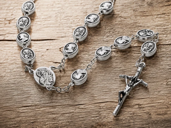 Owalne metalowe paciorki ozdobione są reliefowymi wizerunkami religijnymi.