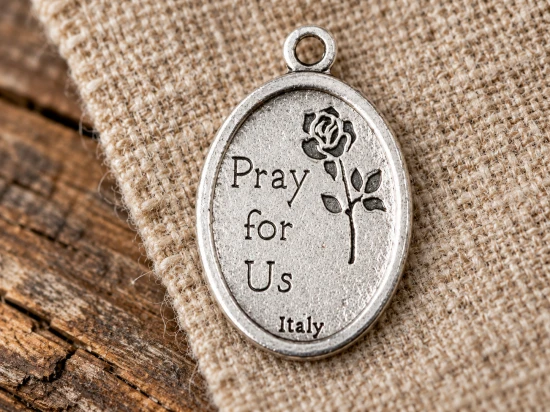 Rewers zdobi róża oraz napis „Pray for Us”, czyli „Módl się za nami”.