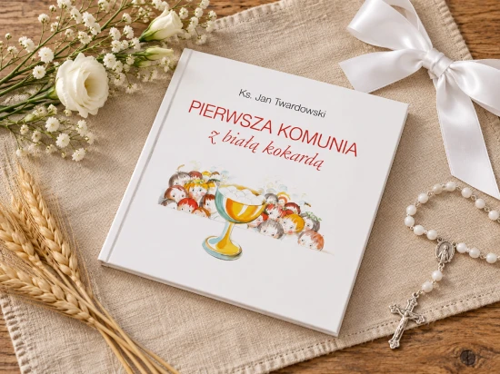 Książka na lnianej tkaninie w komunijnej aranżacji z białą kokardą, różańcem i kłosami.