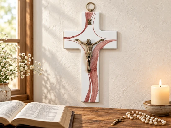Krzyż na jasnej ścianie nad stolikiem z otwartym Pismem Świętym, różańcem i zapaloną świecą.
